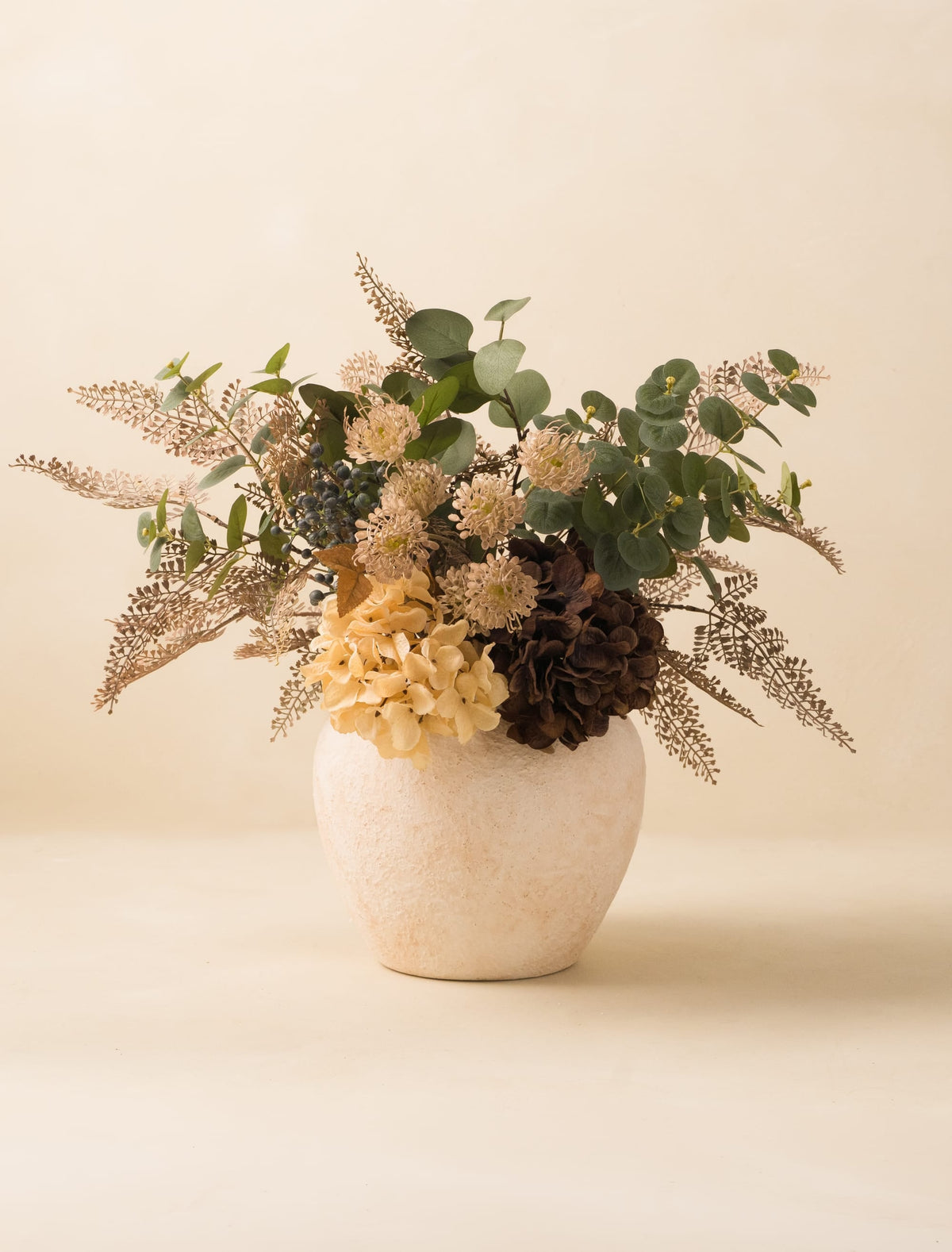 Composition florale artificielle – Fougère taupe et hortensias crème